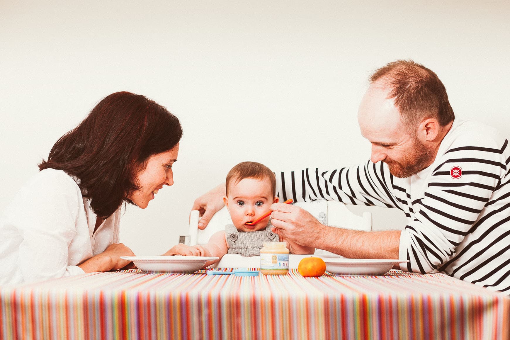 sesion de fotos infantil en casa con padres dando de comer