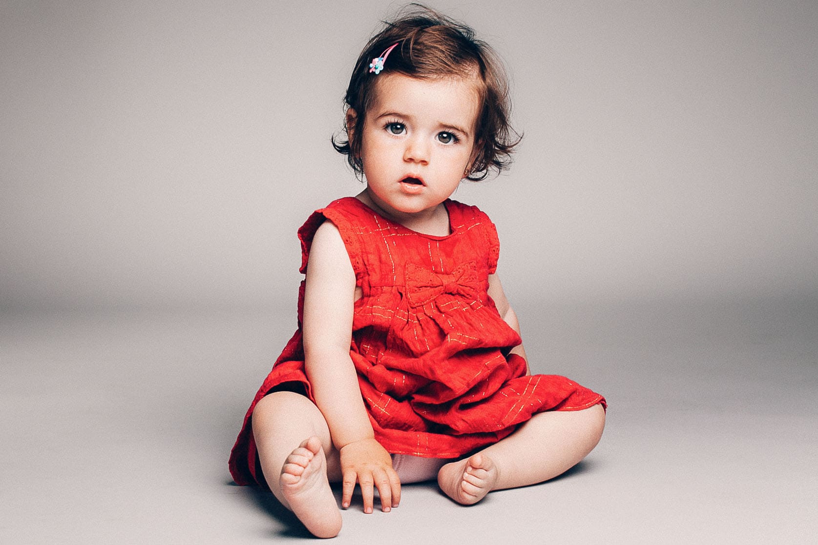 sesion de bebe de niña sentada vestida de rojo