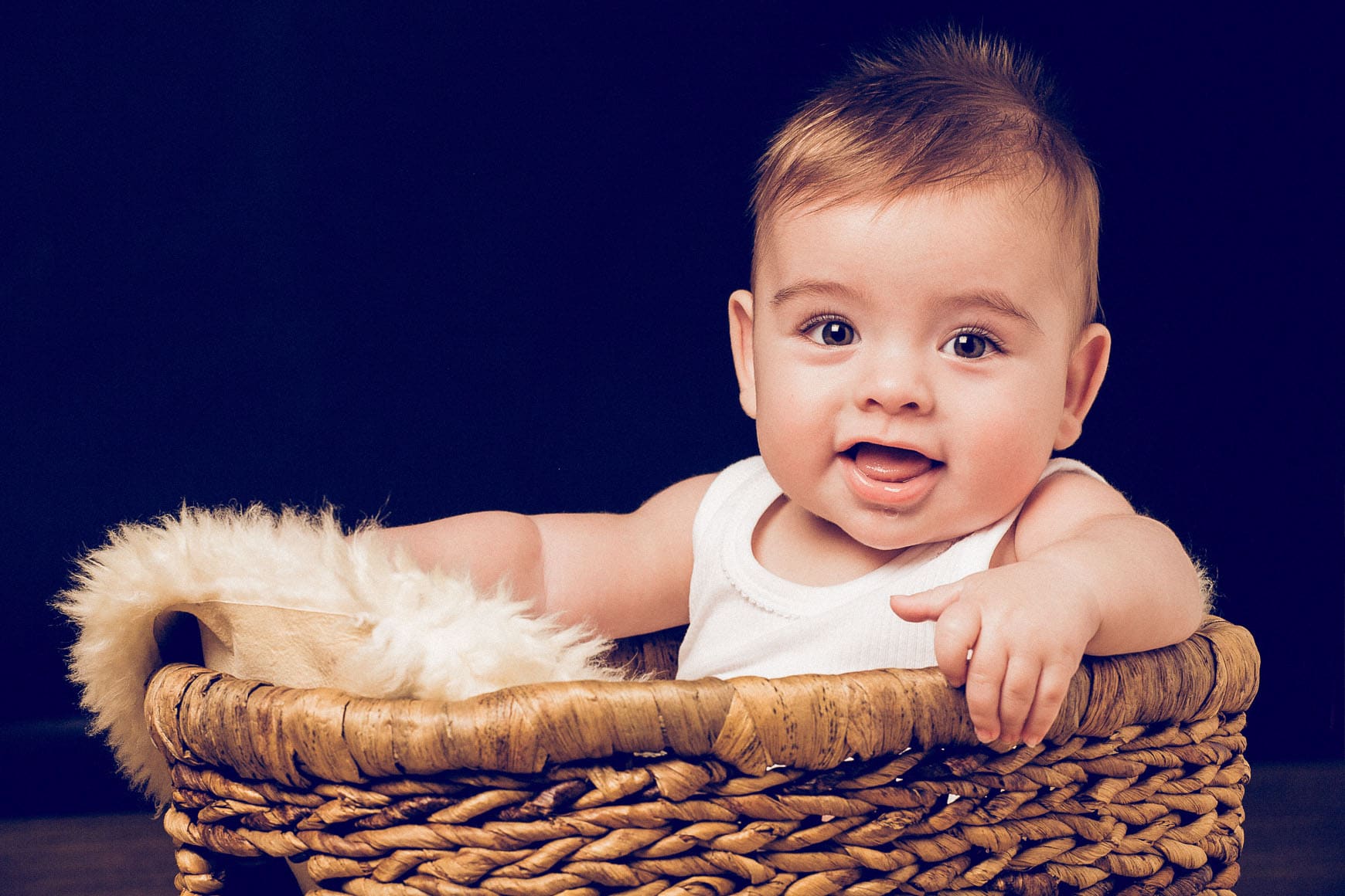 bebe de 9 meses sonriente dentro de un cesto